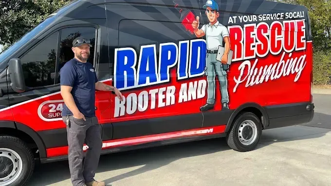 Rapid Rescue plumber standing beside the branded service van